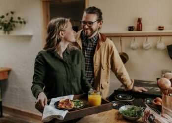 Oudere man en vrouw eten samen een maaltijd met groente aan tafel