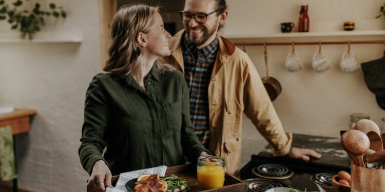 Oudere man en vrouw eten samen een maaltijd met groente aan tafel