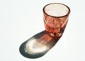 Maatschepje met wit poeder naast een glas water