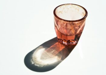 Maatschepje met wit poeder naast een glas water