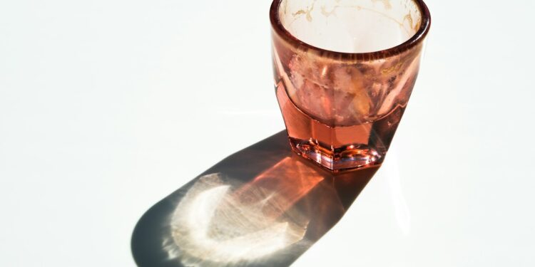 Maatschepje met wit poeder naast een glas water