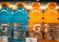 Fles met een heldere fruitige sportdrank op een aanrecht