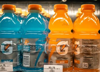 Fles met een heldere fruitige sportdrank op een aanrecht