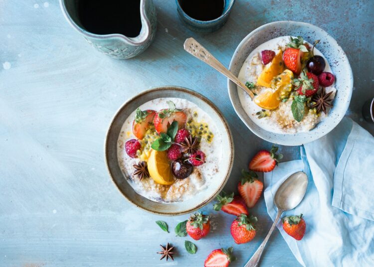 Kom kwark en kom Griekse yoghurt met fruit op een ontbijttafel