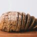 Sneetjes volkorenbrood naast een kom havermout op een houten plank