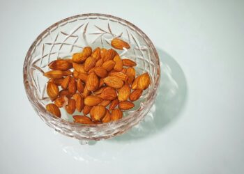 Kom met pompoenpitten en amandelen op een keukentafel