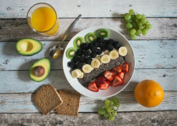 Kom met havermout en fruit op een keukentafel als vast ontbijt