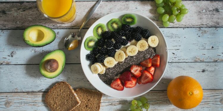 Kom met havermout en fruit op een keukentafel als vast ontbijt
