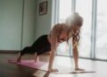 Vrouw houdt een plank op een yogamat