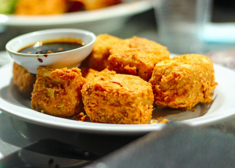 Blokken tofu, tempeh en een glas sojadrink op een keukentafel