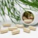 Potje met vitamine D-capsules naast een glas water op tafel