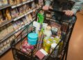 Boodschappenmandje met groente, brood en zuivel in een supermarktgangpad