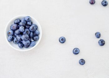 Kom yoghurt met verse blauwe bessen op een keukentafel