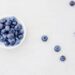 Kom yoghurt met verse blauwe bessen op een keukentafel