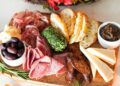 Borrelplank met plakjes worst, kaas en tomaatjes