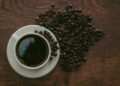 Kop zwarte koffie met koffiebonen op tafel