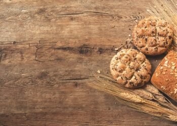 Volkoren knäckebröd naast sneetjes volkorenbrood op een snijplank