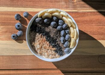 Kom havermout met blauwe bessen op een houten ontbijttafel