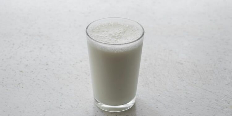 Glas karnemelk en een fles kefir op tafel