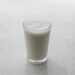 Glas karnemelk en een fles kefir op tafel