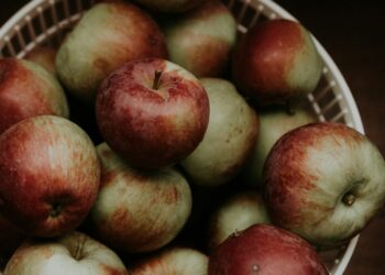 Rode en groene appels in een krat in een boomgaard