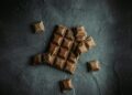 Stukjes pure chocola op een houten plank
