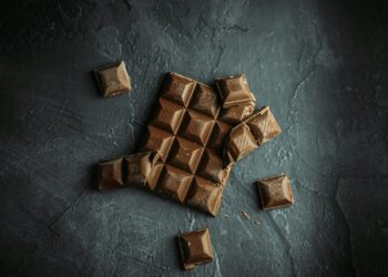 Stukjes pure chocola op een houten plank
