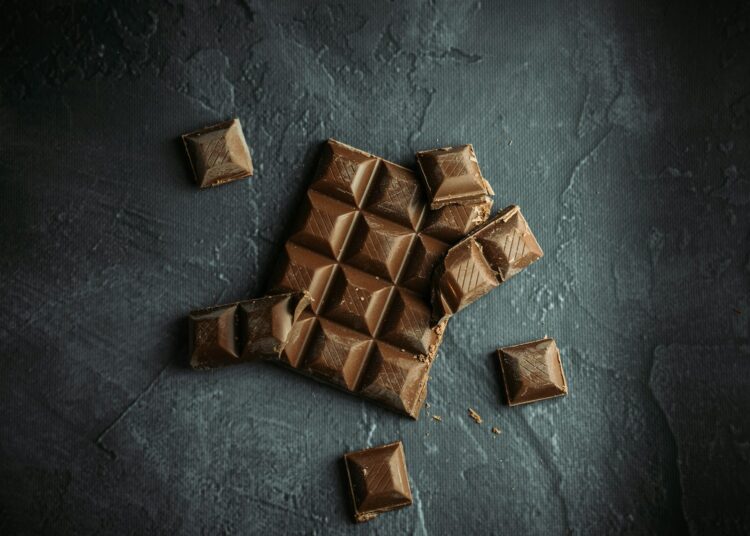 Stukjes pure chocola op een houten plank