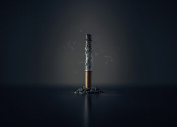 Gebroken sigaret op tafel naast een schaaltje met appel en noten