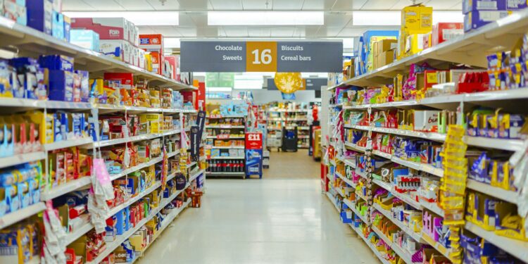 Schappen in de supermarkt vol verpakte levensmiddelen