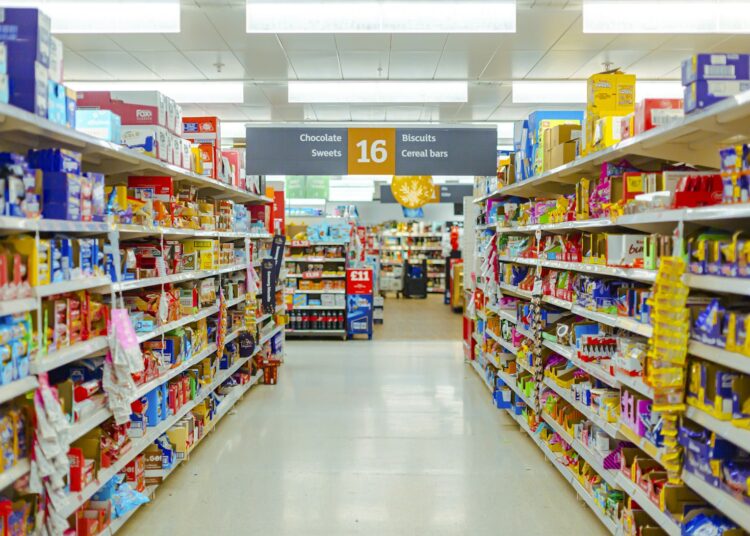 Schappen in de supermarkt vol verpakte levensmiddelen