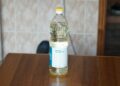 Fles zonnebloemolie naast een koekenpan
