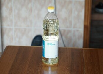Fles zonnebloemolie naast een koekenpan
