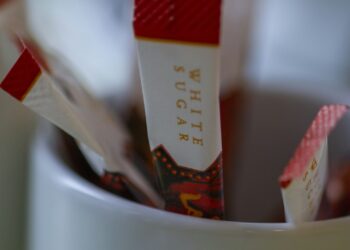 Zoetjes en suikerzakjes naast een kop koffie